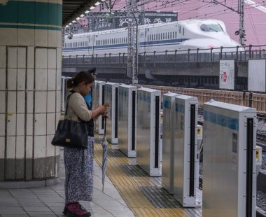 Tokyo, Japonya - 16 Eylül 2018. Gelmesi için bekleyen Yurakucho istasyonu platformu ayakta commuters Tren.
