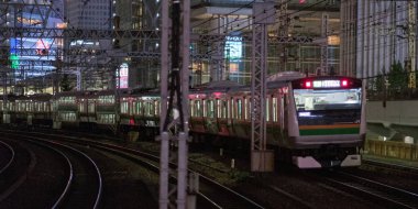 Tokyo, Japonya - 15 Eylül 2018. Blirred hareket thorugh Yurakucho istasyonu geçen Doğu Japonya demiryolu Shonan Shinjuku satırının geceleri izler... Uzun pozlama süresi.
