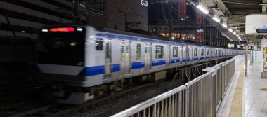 Tokyo, Japonya - 15 Eylül 2018. Geceleri thorugh Yurakucho istasyonu geçen Doğu Japonya demiryolu Keihin Tohoku satırının bulanık hareket izler..