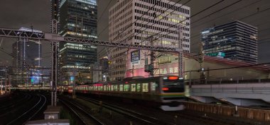 Tokyo, Japonya - 15 Eylül 2018. Blurrred hareket thorugh Yurakucho istasyonu geçen Doğu Japonya demiryolu Shonan Shinjuku satırının geceleri izler... Uzun pozlama süresi.