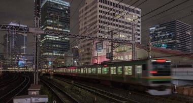 Tokyo, Japonya - 15 Eylül 2018. Blurrred hareket thorugh Yurakucho istasyonu geçen Doğu Japonya demiryolu Shonan Shinjuku satırının geceleri izler... Uzun pozlama süresi.