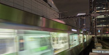 Tokyo, Japonya - 15 Eylül 2018. Bulanık hareket thorugh Yurakucho istasyonu geçen Doğu Japonya demiryolu Yamanote satırının geceleri izler... Uzun pozlama.