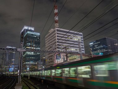Tokyo, Japonya - 15 Eylül 2018. Blirred hareket thorugh Yurakucho istasyonu geçen Doğu Japonya demiryolu Shonan Shinjuku satırının geceleri izler... Uzun pozlama süresi.