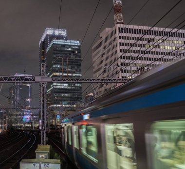 Tokyo, Japonya - 15 Eylül 2018. Geceleri thorugh Yurakucho istasyonu geçen Doğu Japonya demiryolu Keihin Tohoku satırının bulanık hareket izler..