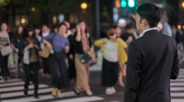Tokyo, Japonya - 15 Eylül 2018. Geceleri Yurakucho sokakta geçmeye bekleyen iş takım elbiseli adam.