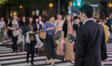 Tokyo, Japonya - 15 Eylül 2018. Geceleri Yurakucho sokakta geçmeye bekleyen iş takım elbiseli adam.