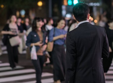 Tokyo, Japonya - 15 Eylül 2018. Geceleri Yurakucho sokakta geçmeye bekleyen iş takım elbiseli adam.
