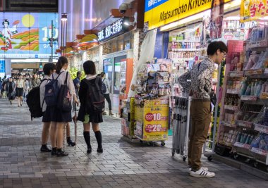 Tokyo, Japonya - 15 Eylül 2018. Liseli kız Yurakucho tren istasyonu önünde küçük dükkanlar, aylak aylak dolaşıyor ' gece.