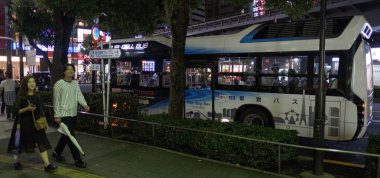 TOKYO, JAPAN - SEPTEMBER 15TH, 2018. Toyota's Fuel Cell Bus going around its designated route in Ginza street at night. clipart