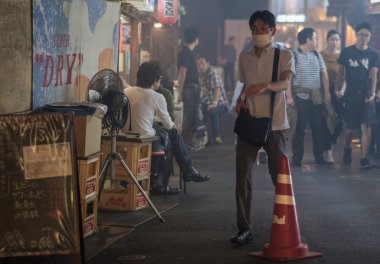 Tokyo, Japonya - 15 Eylül 2018. yürüyüş erkek dumanlı küçük atılmış bir tünel altında demiryolu parça Yurakucho sokakta geceleri geçmesi.