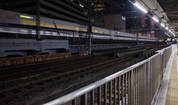 2018 東京都 夜の有楽町駅の線路を通過する日本高速弾丸列車のぼやけた映像 — ストック写真