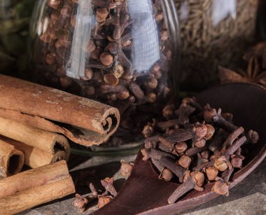 tarçın çubukları ve ahşap masa üzerinde çeşitli baharatlar.