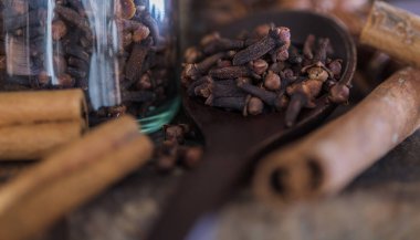 ahşap masa üzerinde kurutulmuş karanfil ve çeşitli baharatlar.