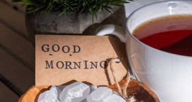 Beyaz ahşap arka planda çay fincan ile Günaydın etiket görünümü yakın