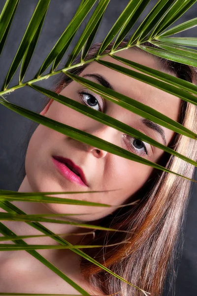 Nahaufnahme Eines Weiblichen Gesichts Hinter Einen Palmenblatt — Stockfoto