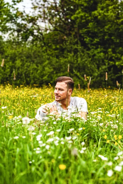 Mladý Muž Sedí Vysokém Květinových Polích — Stock fotografie