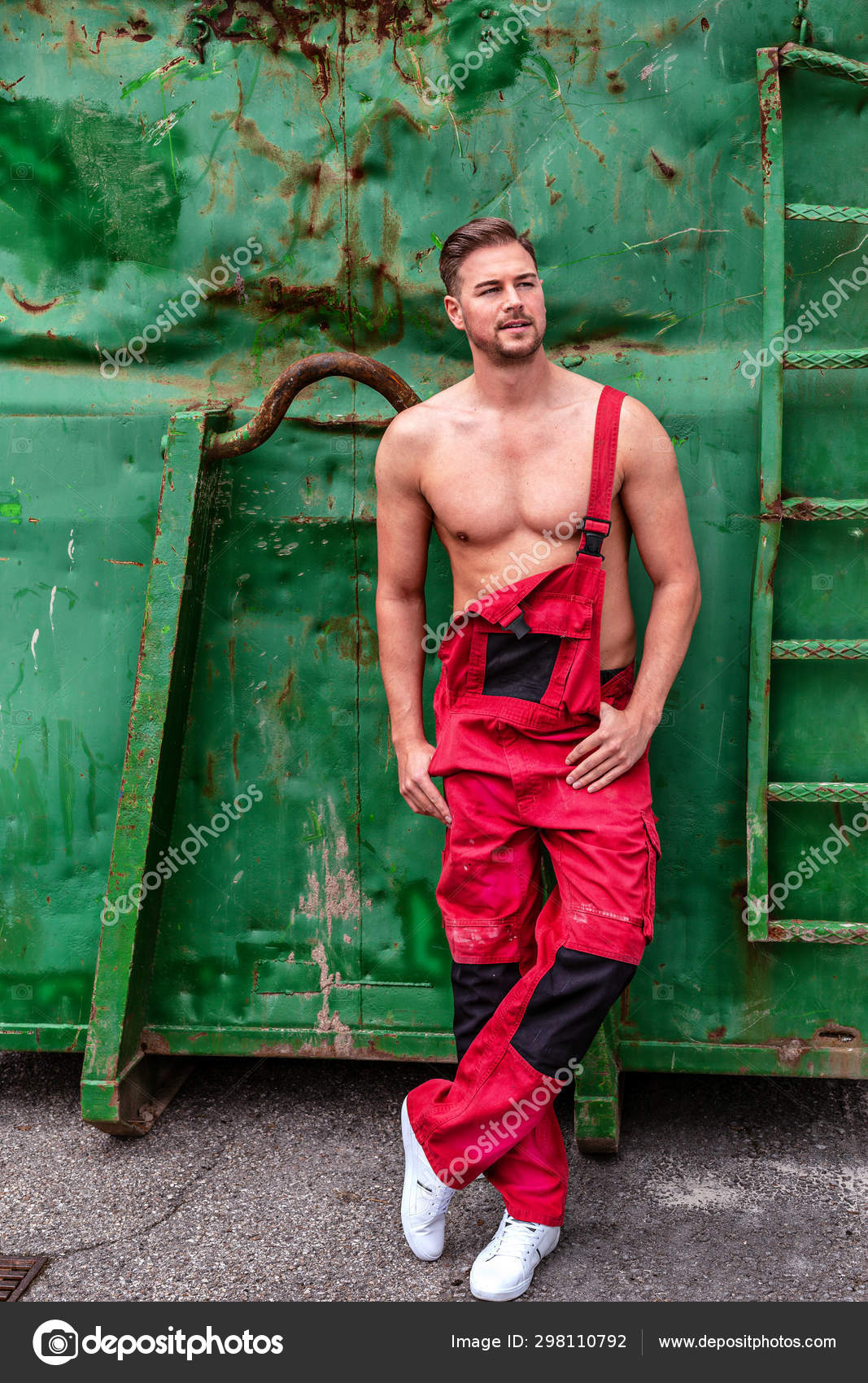 Ledig Implement Misbrug Muscular Young Man Leaning Old Green Container Red Dungarees Stock Photo by  ©STphotography 298110792