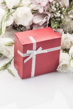 Bir kırmızı hediye kutusu ve kopya alanı ile beyaz çiçekler