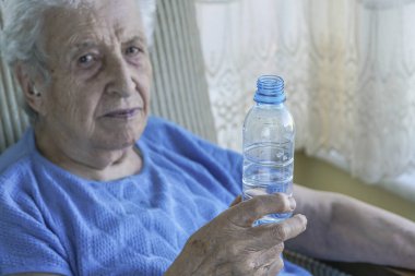 İçme suyu bir şişe tutan bir üst düzey kadın