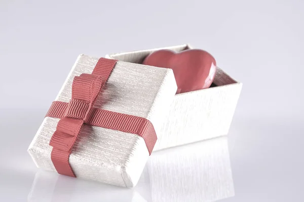 一颗红色的心在打开的礼品盒上白色与反射 — 图库照片