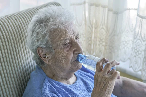 素敵な年配の女性がボトルから水を飲む — ストック写真