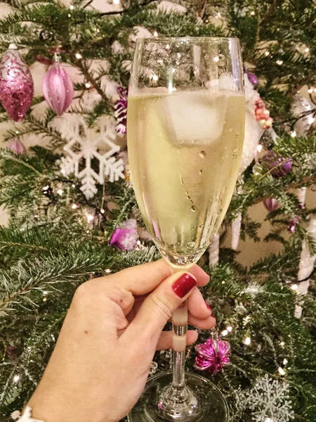 Eine Hand Hält Ein Glas Wein Gegen Den Weihnachtsbaum — Stockfoto