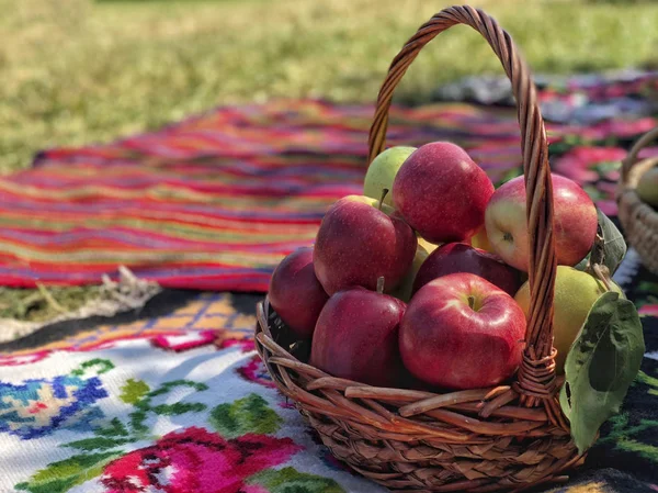 Ripe red apples in a basket at park