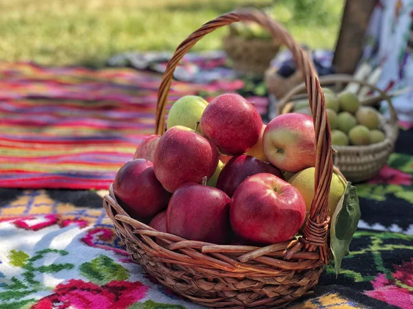 Ripe red apples in a basket at park