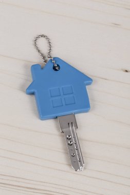 bir anahtarla ev ahşap masa üzerinde mavi anahtarlık şeklinde