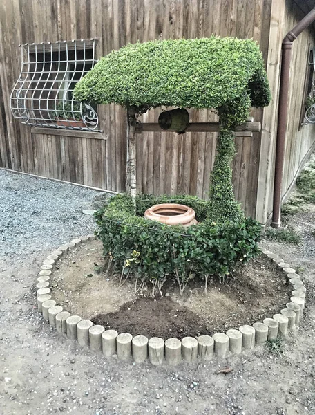 An artesian water well with wooden drive shaft in garden