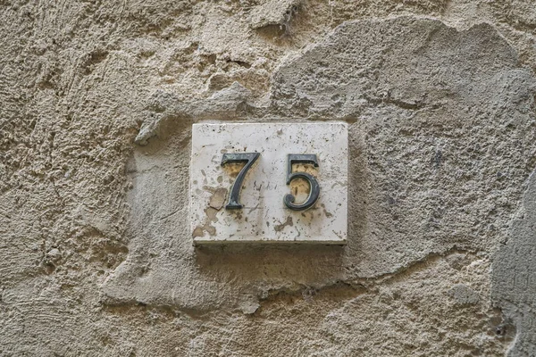 number seventy five on a wall with copy space