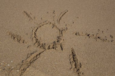 arka plan el ile güneş şekil kumlu bir plaj üzerinde çizilmiş.