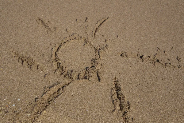 arka plan el ile güneş şekil kumlu bir plaj üzerinde çizilmiş.