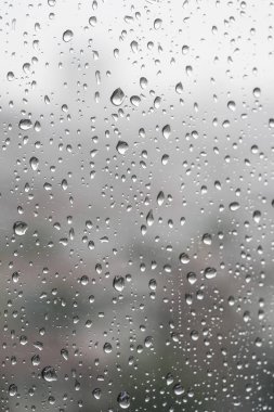 Yağmurlu bir günde pencere camında yağmur damlaları olan arkaplan