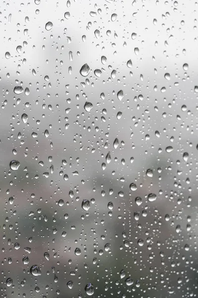 Yağmurlu bir günde pencere camında yağmur damlaları olan arkaplan