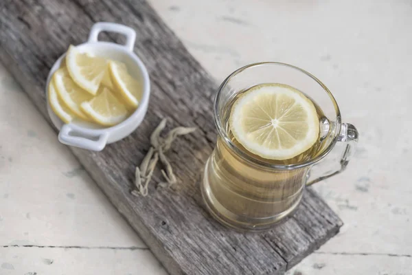 Ein Glas Kräutertee auf einem Holztisch — Stockfoto