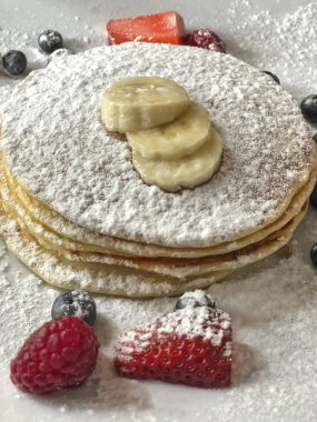 tabakta krep çilek ve muz ile süslenmiş