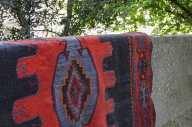 kuruması için bahçede asılı bir el halı yaptı