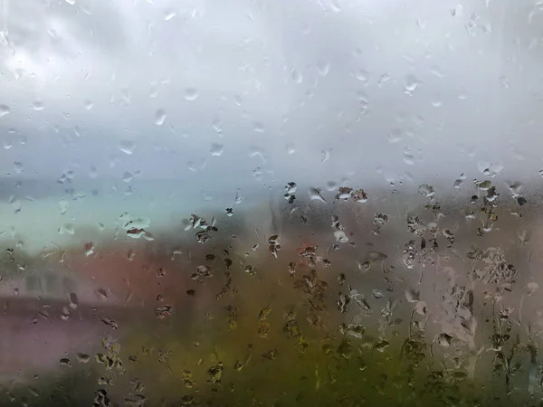 Regentropfen auf Fenster an einem regnerischen Tag — Stockfoto