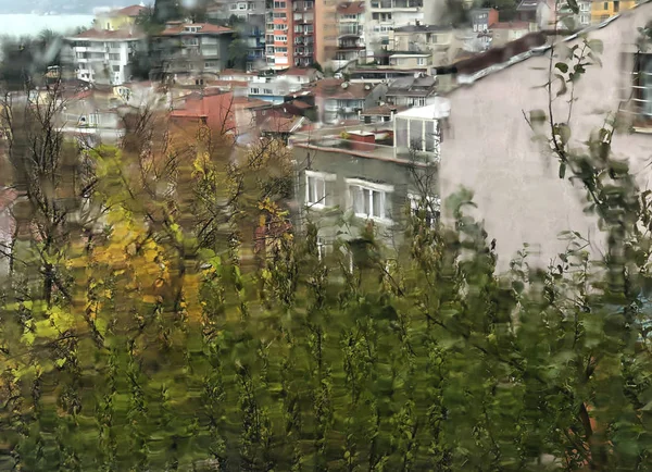 Bulurred bakgrund med regndroppar på fönster mot byggnader — Stockfoto