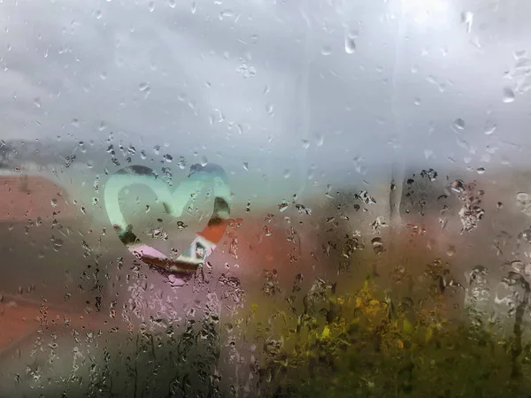 Heart shape on the wet window pane with rain drops — Stock Photo, Image