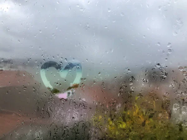 Herzform auf der nassen Fensterscheibe mit Regentropfen — Stockfoto