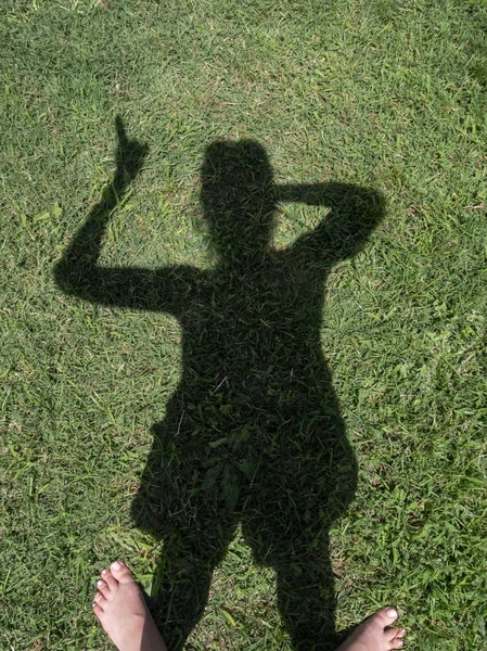 Sombra de uma mulher com reflexão sobre a grama — Fotografia de Stock