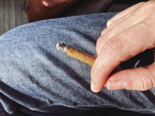 Mão segurando um cigarro entre os dedos — Fotografia de Stock