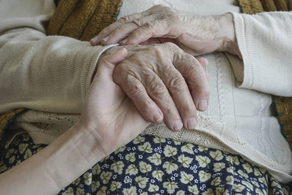 A hand holding an older wrinkled hand — Stock Photo, Image
