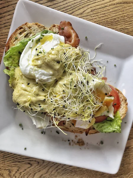 Benedict de ovo com presunto e salada em um pão de torrada — Fotografia de Stock