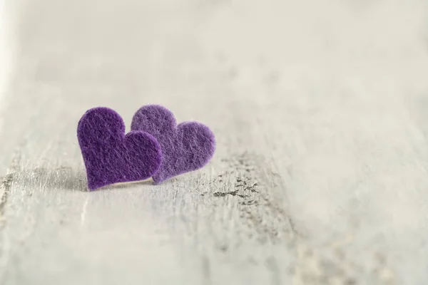 purple hearts on a wooden background with copy space