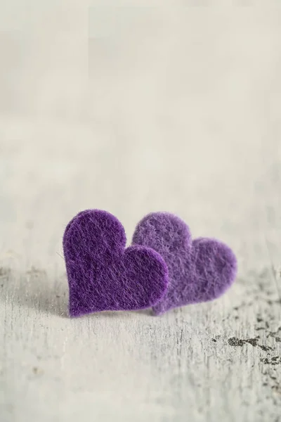 purple hearts on a wooden background with copy space