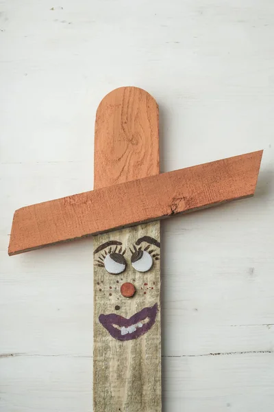 wooden scarecrow painted like people with a funny face