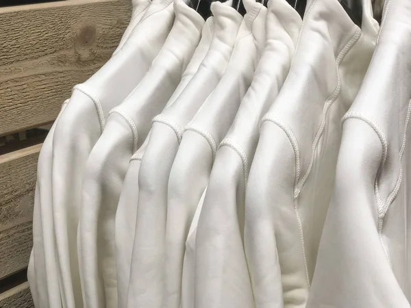 Weiße Kleidung in einer Schaufensterscheibe aufgehängt — Stockfoto